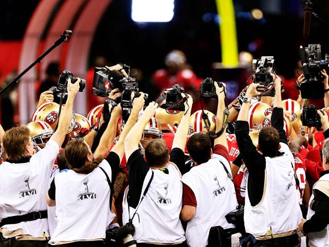 Photographers take pictures of members of the San Francisco 49ers huddling up prior to the start of Super Bowl XLVII against the Baltimore Ravens at the Mercedes-Benz Superdome in New Orleans, Louisiana.(AFP Photo)