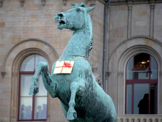 A golden Leibniz cookie hangs from a horses neck in front of the Leibniz University in Hannover, Germany. AP Photo