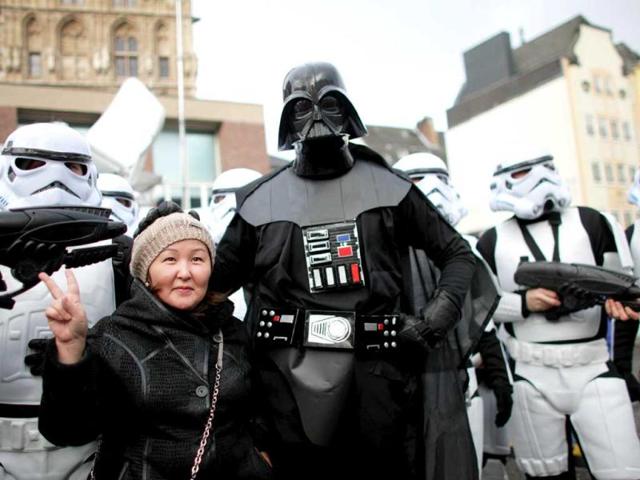 A woman poses with fools dressed as Darth Vader and star troopers during the beginning of the street carnival in Cologne, western Germany as the hot carnival season was launched. AFP Photo