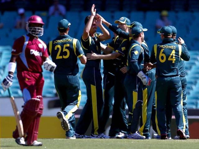 West Indies batsman Narsingh Deonarine walks off the ground as member of the Australian team celebrate his dismissal for ten runs during their limited overs international cricket match at the Sydney Cricket Ground. Reuters/Daniel Munoz
