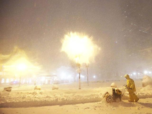 A man operates a snowblower while a blizzard arrives in the Back Bay neighborhood in Boston, Massachusetts. AFP