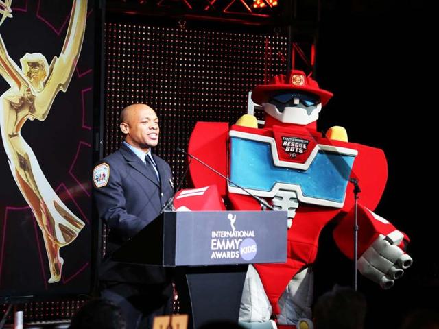 FDNY Firefighter Daniel Glover performs with Transformers Rescue Bot, Heatwave, during the International Emmy Kids Awards at Chelsea Piers in New York. (AP/International Academy of Arts and Sciences