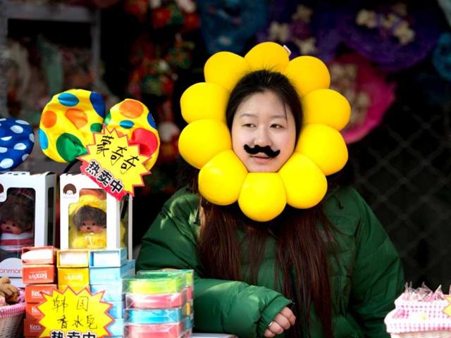 A vendor waits for customers in her stall at a temple fair in Ditan park in Beijing a day before the Lunar New Year. (AFP Photo)