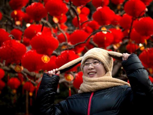 A woman poses before lanterns at a temple fair in Ditan park in Beijing a day before the Lunar New Year. (AFP Photo)