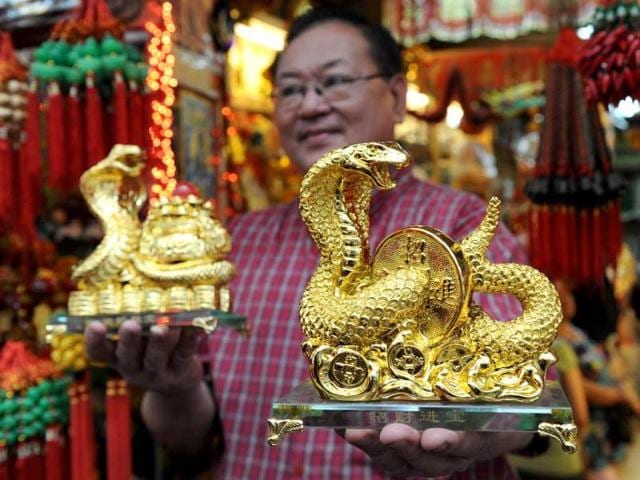 A store owner shows snake ornaments on the eve of the Chinese Lunar New Year of the Snake, Manila. (AFP Photo)