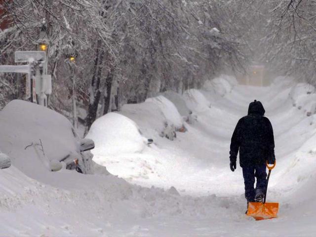 A man drags a shovel up Beacon Hill during a severe winter snow storm in Boston, Massachusetts. Reuters