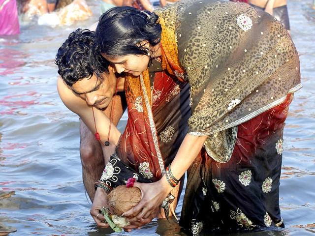 A couple releases offering into the Sangam on the occasion of Mauni Amawasya in Allahabad. HT Photo/Ajay Aggarwal