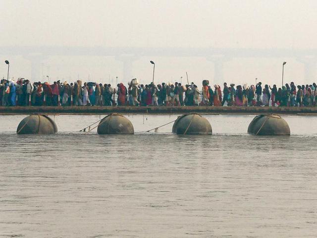 Hindu-devotees-walk-across-a-pontoon-bridge-for-a-holy-dip-at-Sangam-the-confluence-of-the-Ganges-the-Yamuna-and-the-Saraswati-rivers-during-the-Maha-Kumbh-festival-in-Allahabad--The-death-toll-from-a-stampede-in-a-train-station-rose-to-36-today-AP-Photo