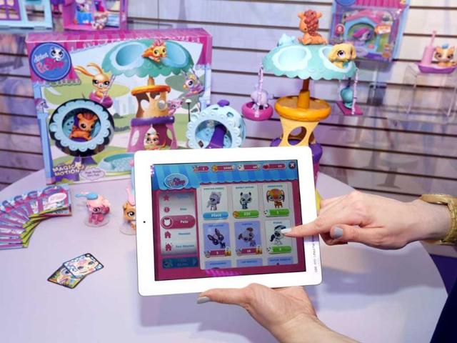 Demonstrator Chrysten Peddie plays the popular littlest pet shop app in Hasbro's showroom at the American International Toy Fair in New York. AP/Jason DeCrow/Invision for Hasbro