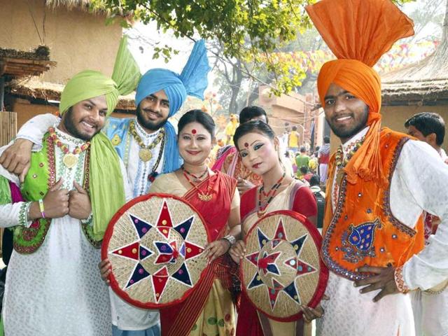 Folk artists pose one for camera during Surajkund International Crafts Mela in Faridabad. Photo: PTI