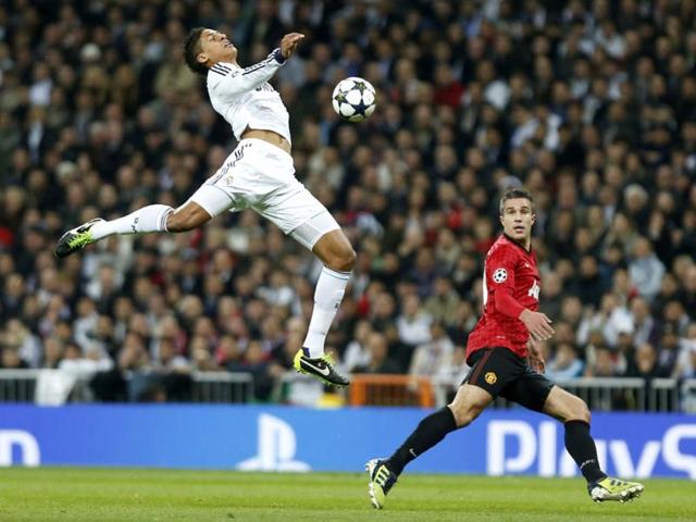 Manchester United's Robin van Persie watches as Real Madrid's Raphael Varane from France tries to intercept the ball during the Champions League match between Real Madrid and Manchester United at the Santiago Bernabeu stadium in Madrid. AP Photo