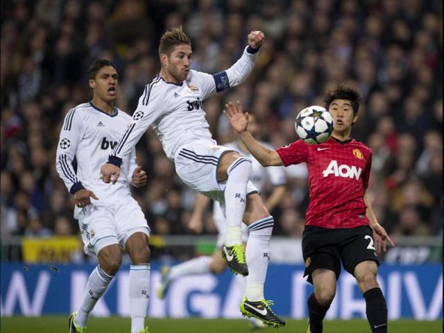 Real Madrid's defender Sergio Ramos (C) vies with Manchester United's Japanese midfielder Shinji Kagawa (R) during the UEFA Champions League match between Real Madrid and Manchester United at the Santiago Bernabeu stadium in Madrid. AFP