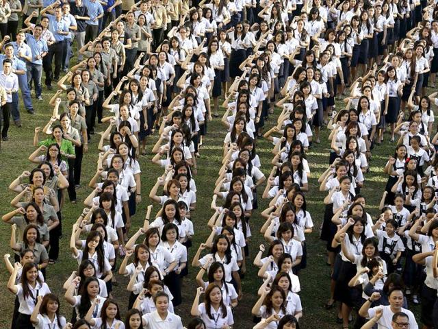 Filipino theater artist Monique Wilson flashes the No.1 sign with students from St. Scholastica's College, an all-girls' school, as they dance at their campus in a global kickoff campaign dubbed One Billion Rising, to end violence against women and children on Valentine's Day in Manila, Philippines. (AP Photo)