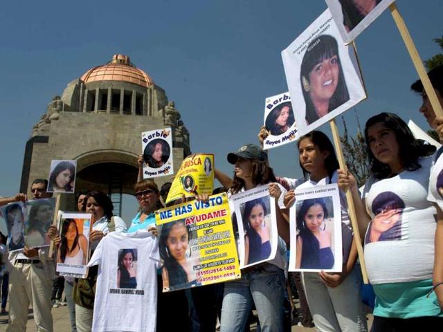 People show pictures of missing women during Mexico's "One Billion Rising" flashmob against violence against women, at the Republic Square in front of the Monument to the Mexican Revolution, in Mexico City. AFP/Yuri Cortez