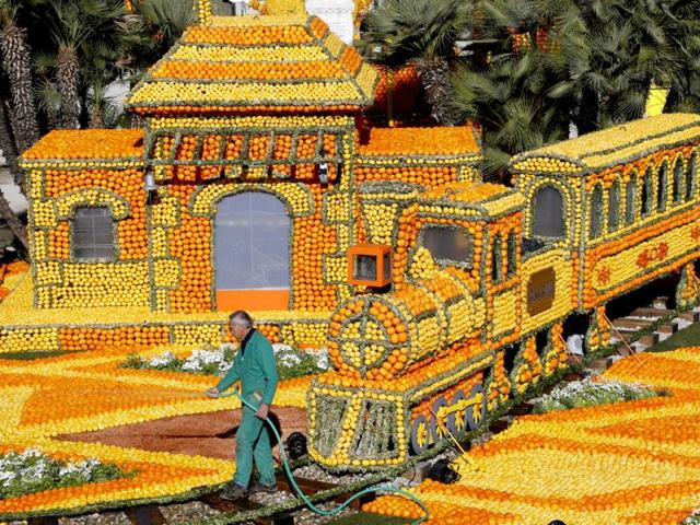 A man works on "The rail road with Big Ben" a sculpture made of oranges and lemons in Menton on the French Riviera, ahead of the start of the "Fete du Citron" (lemon carnival). AFP