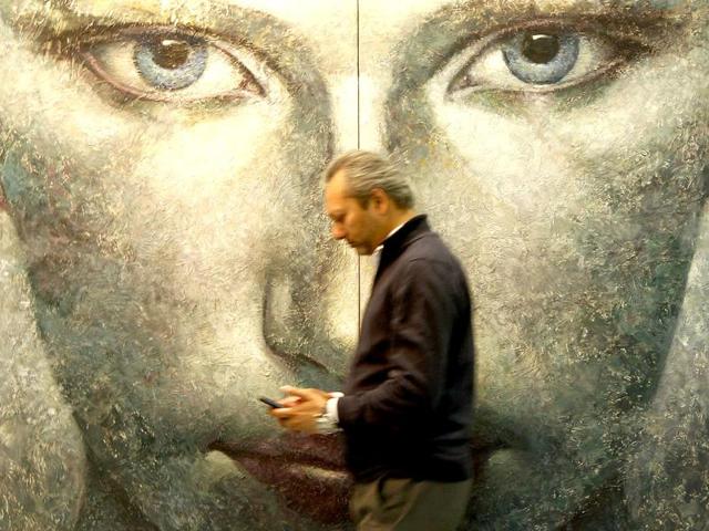 A man walk past a work at India Art Fair