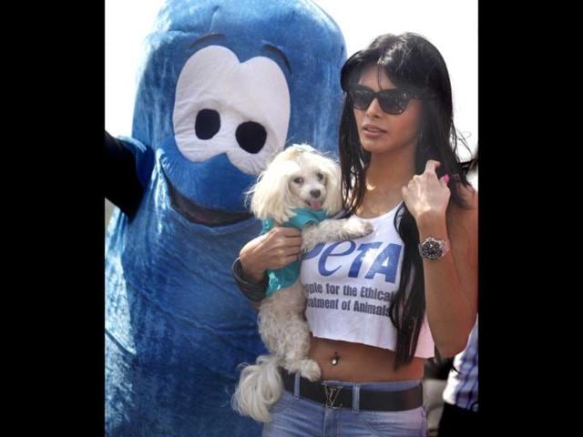 Sherlyn Chopra holds her pet poodle as she leaves after attending an awareness campaign by PETA in Mumbai on Tuesday. (HT Photo)