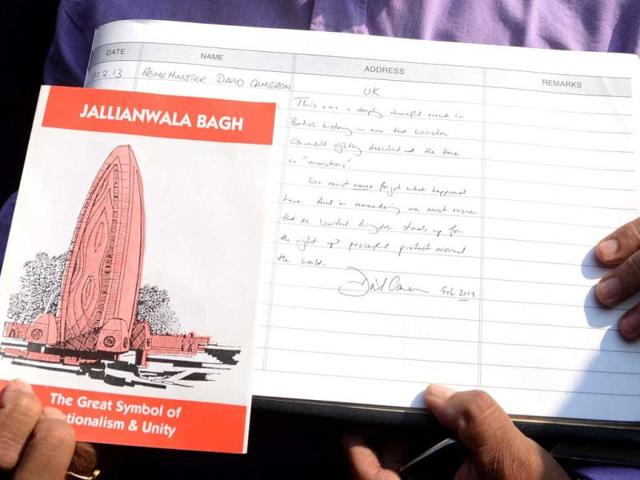 An official displays the visitor book after British Prime Minister David Cameron wrote his remarks at Jallianwala Bagh memorial in Amritsar. AFP photo