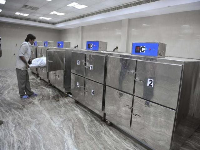 A hospital worker handles a victim of a bomb blast in the mortuary of Osmania Hospital in Hyderabad. Twin bombings killed at least 14 people on Thursday outside a cinema and bus stand in the city. AFP