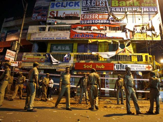 Policemen guard a shopping arcade, damaged in one of the two bomb blasts in Hyderabad. AP
