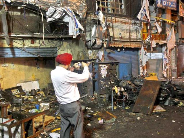 An investigative official takes photographs of the debris at one of the two bomb blast sites in Hyderabad. AP
