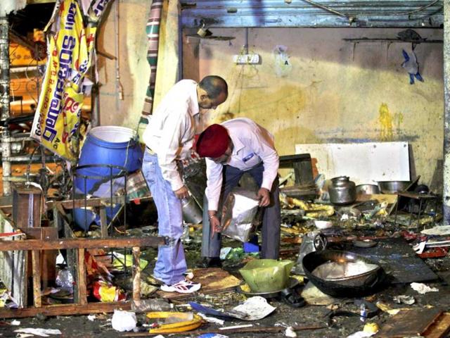 An investigative official holds evidence collected from the debris at one of the two bomb blast sites in Hyderabad. AP