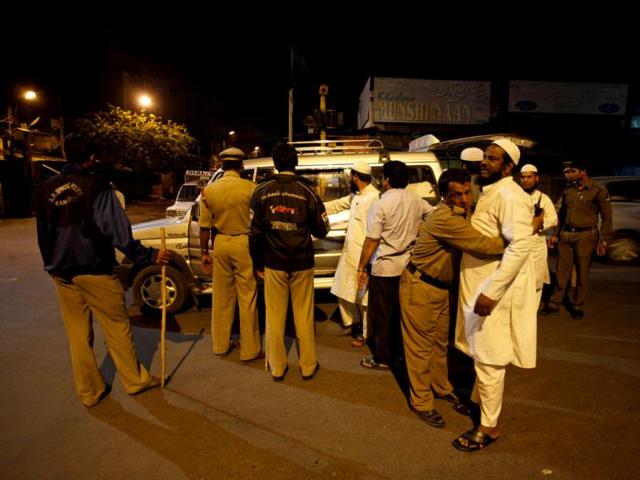 Police check commuters on a road after security was enhanced following twin explosions in Hyderabad. AP