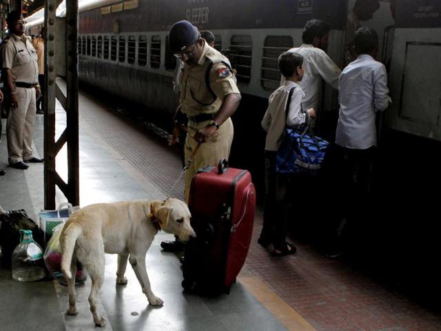 A railway police officer with a sniffer dog inspects the luggage of a passenger in Mumbai following twin explosions in Hyderabad. (HT Photo)