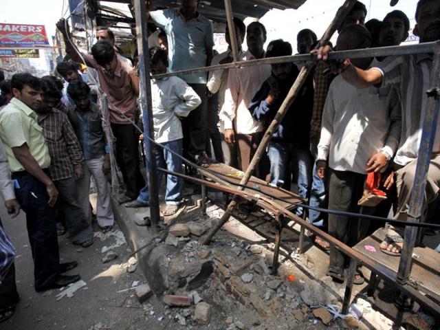 People gather at one of the two bomb blast sites in Hyderabad. The surveillance camera installed in front of Dilsukhnagar bus station captured the image of a suspect. AP/Mahesh Kumar A