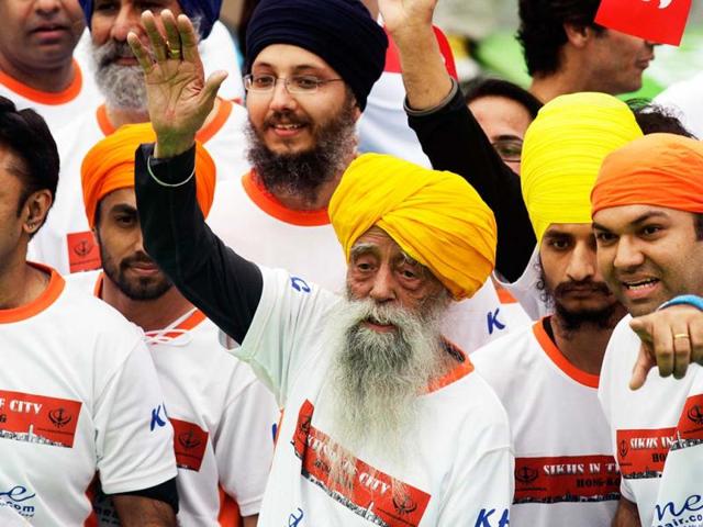 British Indian marathon runner Fauja Singh, 101, and accompanied by othet runners wave to fans after finishing the 10-kilometer race of the Hong Kong Marathon. Singh retired from competitive races after the marathon. Reuters photo