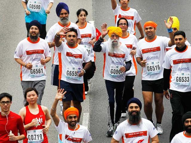 Marathon runner Fauja Singh, 101, center, originally from Beas Pind, in Jalandhar, now living in London, runs in a 10-kilometer race, part of the annual Hong Kong Marathon. AP photo