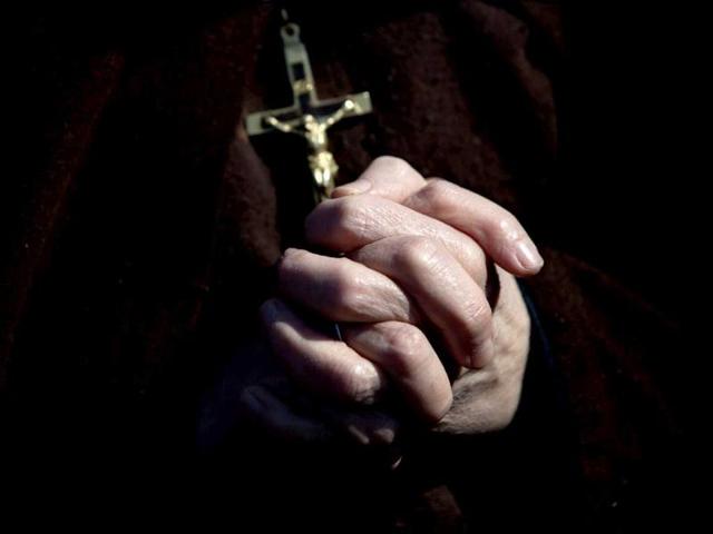 A faithful attends, with a cross in hand, Pope Benedict XVI's last general audience in St Peter's Square, at the Vatican. Benedict stopped to kiss and bless half a dozen children handed to him by his secretary. AP/Oded Balilty