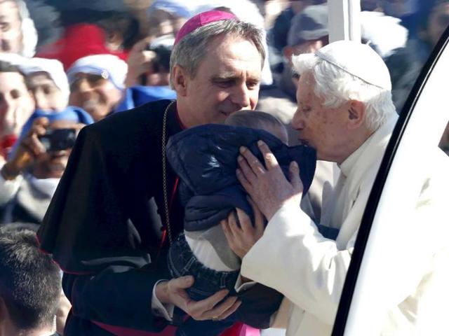Pope Benedict XVI kisses a baby, held by his personal secretary Georg Gaenswein, as he arrives in St Peter's Square. He said he had great trust in the Church's future and asked for prayers for cardinals choosing his successor at a time of crisis. Reuters/Alessandro Bianchi