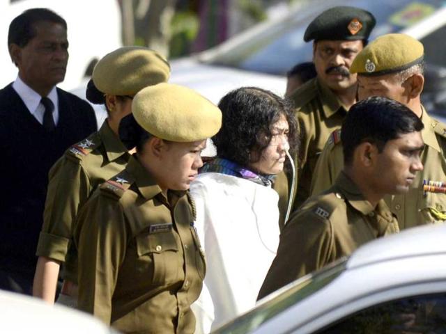 Anti-AFSPA activist Irom Sharmila (C, in white) walks with security personnel as she arrives for an appearance at Patiala court in New Delhi. AFP PHOTO