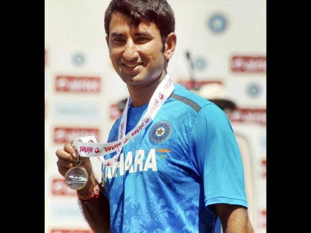 Pujara poses for photographs after being awarded Man of the Match following India's win over Australia in the 2nd cricket test match in Hyderabad. PTI Photo