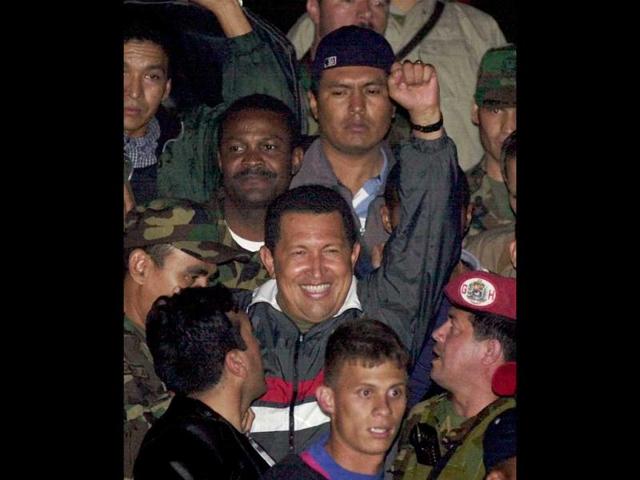 Venezuela's President Hugo Chavez gestures to supporters as he arrives to Miraflores presidential palace after being freed by his military captors two days after the military announced he had resigned in Caracas, Venezuela. (AP)