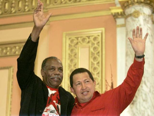 Venezuela's President Hugo Chavez and US actor Danny Glover wave to a crowd gathered at the Mount Olive Baptist Church in the Harlem neighborhood of New York. (AP)