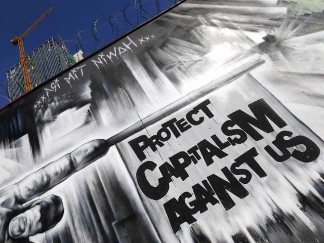 A graffiti is seen outside a fence surrounding the construction site for the new headquarters of the European Central Bank (ECB) in Frankfurt. Reuters