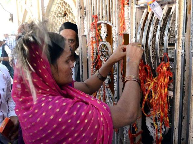 A Muslim devotee ties a scared thred while offering prayers at the Ajmer Sharif shrine in Ajmer. (AFP)