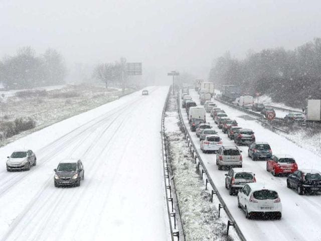Cars drive in the morning traffic on the N118 road around Paris, during a heavy snow storm on France. (AFP)