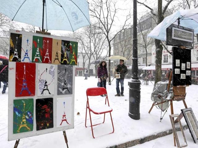 Paintings are displayed on the snow-covered 'Place du Tertre', a square at the Butte Montmartre area near the Sacre Coeur basilica in Paris as winter weather with snow and freezing temperatures returns to northern France. (Reuters)