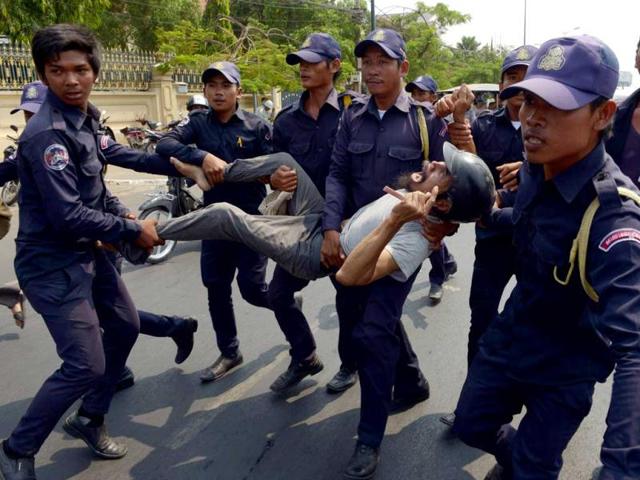 Cambodian security guards arrest a man from Boeung Kak lakeside community during a protest at a park near Prime Minister Hun Sen's house in Phnom Penh. AFP photo