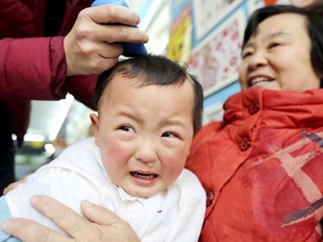 A child cries while getting a haircut at a barber shop in Huaibei, Anhui province on the second day of the second month of the Chinese lunar calendar, which falls on March 13 this year, will bring good luck. Reuters photo