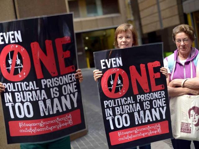 People hold placards during a protest by Myanmar activists against the Myanmar army in front of the Australia Department of Foreign Affairs and Trade (DFAT) in Sydney. AFP/Saeed Khan
