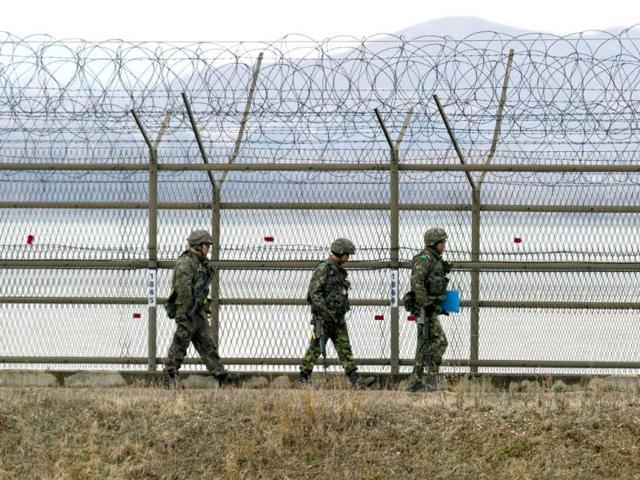 South Korean soldiers patrol along an iron fence fortified with barbed wire near the Demilitarized Zone (DMZ) dividing the two Koreas in the border city of Paju. AFP/Jung Yeon-Je