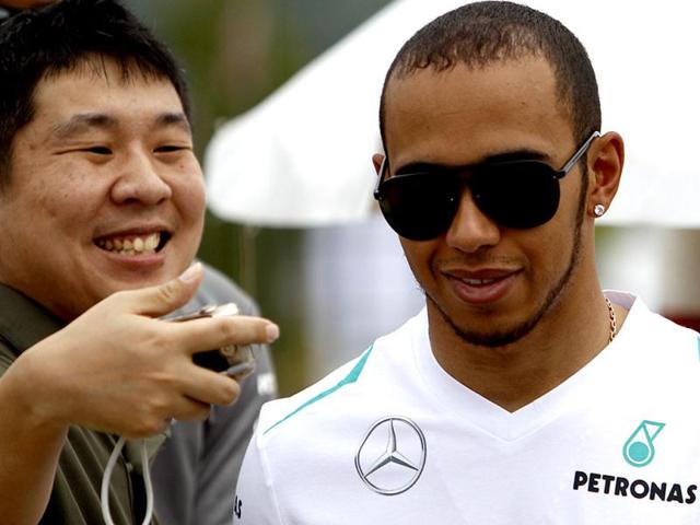 Mercedes F1 driver Hamilton of Britain takes a picture with a fan as he arrives in Sepang, Kuala Lumpur. (Reuters)