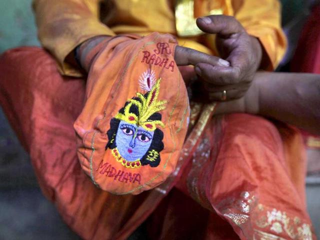 A priest prays holding a bag with an image of Krishna at the Ladali or Radha temple during the Lathmar Holy festival in Barsana. (AP)