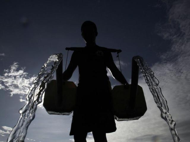 A farmer is silhouetted as he pours water, which he collected from a well, onto his bitter melon plants in Taguig City, Metro Manila. (Reuters)
