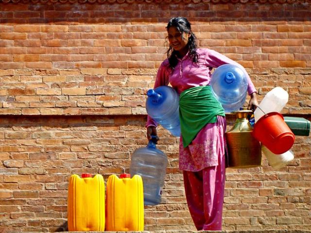 A Nepalese woman waits to fill her vessels with water near Patan in Nepal, Katmandu. (AP)