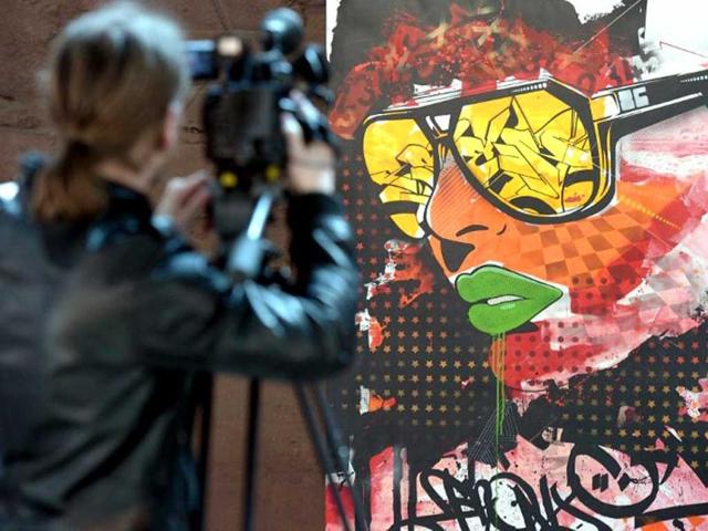 A cameraman films a painting by US graffiti an artist at the 'Urban Art Graffiti 21' exhibtion at the World Cultural Heritage Site at the Volklingen Ironworks. (AFP Photo)